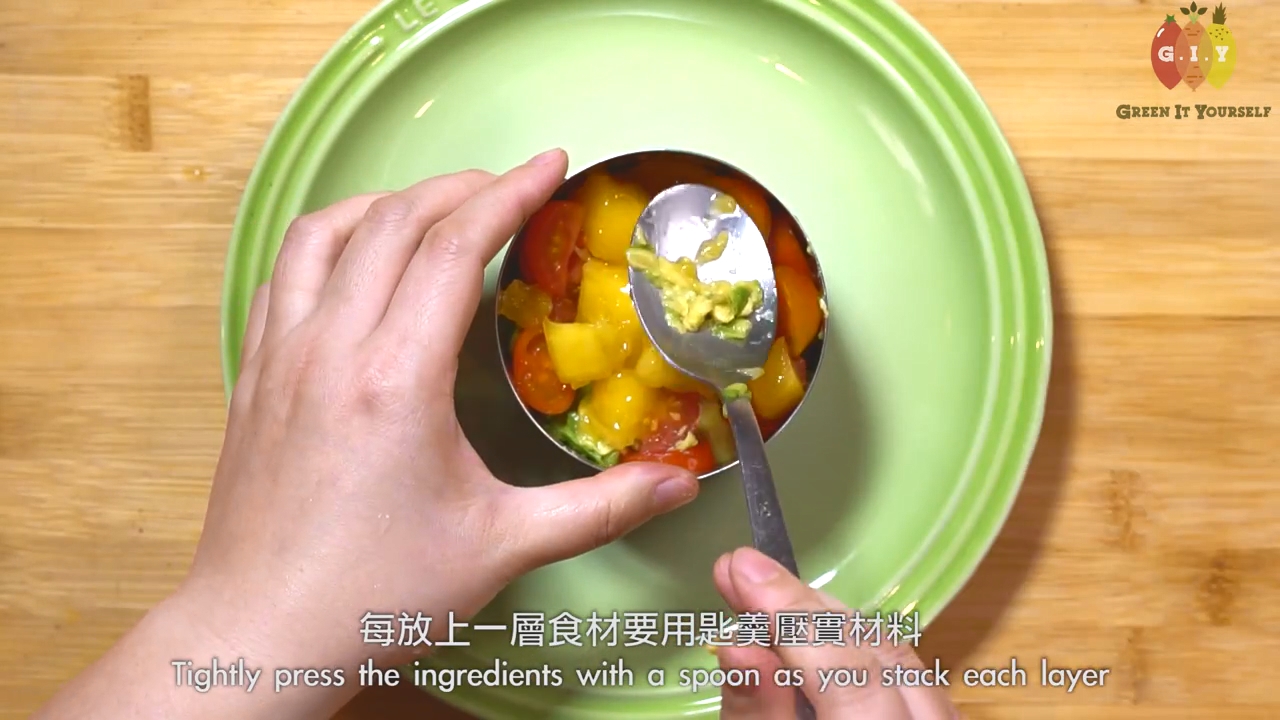 碟上放上一個圓模，先放牛油果、車厘茄、芒果、紅菜頭，用匙羹輕輕壓實。在面排上青瓜片和水蘿蔔片。