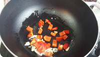 燒熱油鍋，加入蒜片及紅燈籠椒炒香
