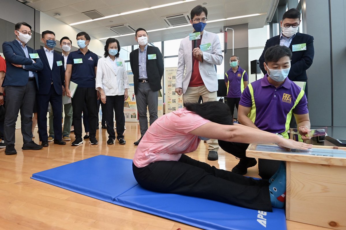 了解體質:  徐英偉（左六）到荃灣體育館出席全港社區體質調查約章簽署儀式，並與嘉賓參觀場館內的體質測試設備。