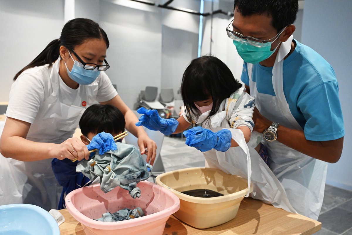 合力創作:  在扎染技巧工作坊中，參與計劃的家庭全家動員，一起製作圖案布袋。