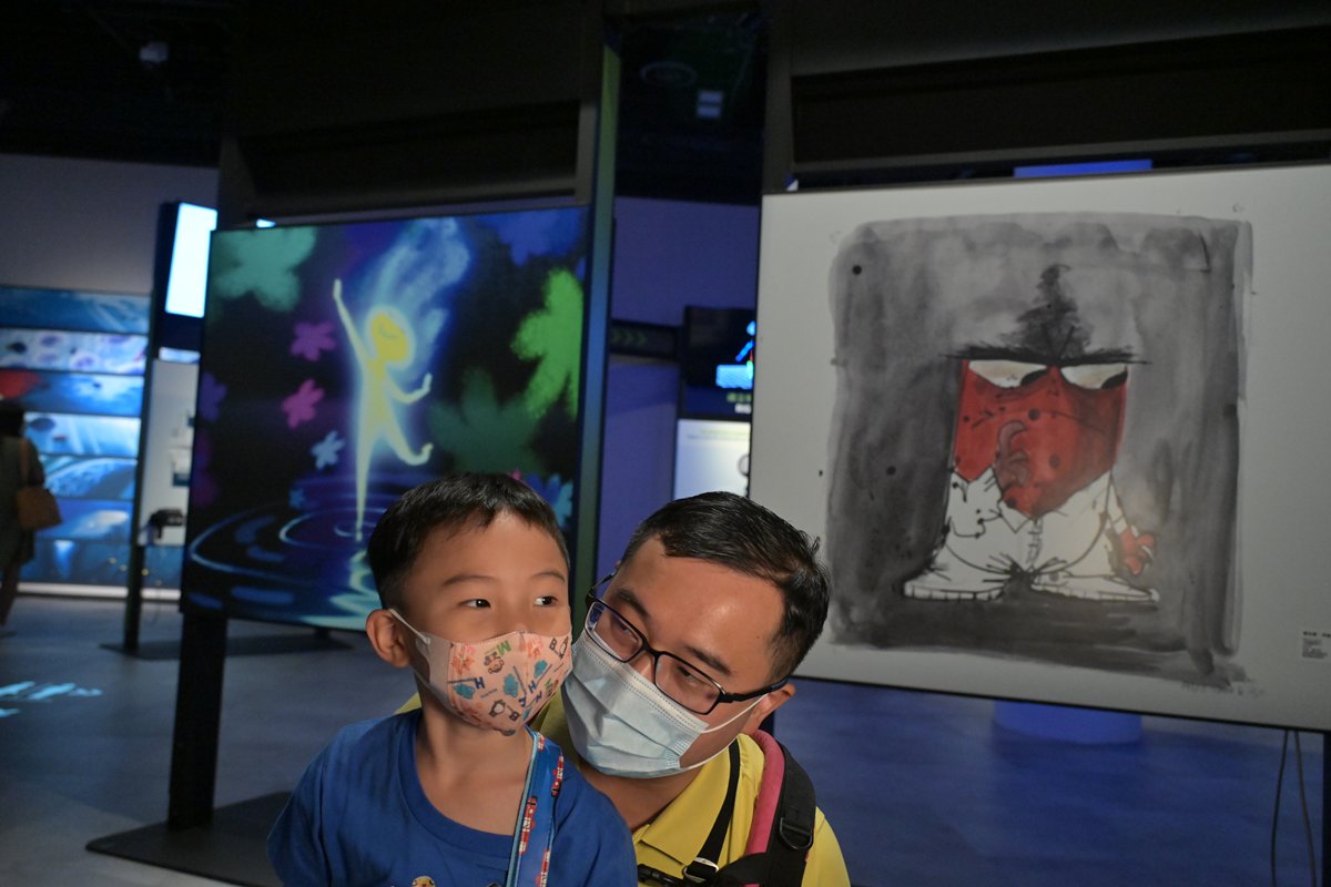 暑期活動:  訪客蔡先生（右）對展覽非常欣賞，希望兒子藉此對科學有基本認知。　