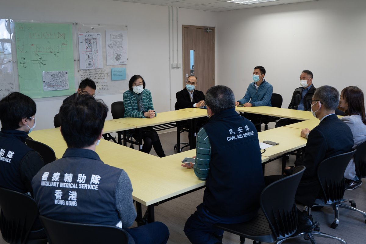 堅守防線:  陳肇始（後排左二）聽取相關部門人員匯報竹篙灣檢疫中心的運作情況。