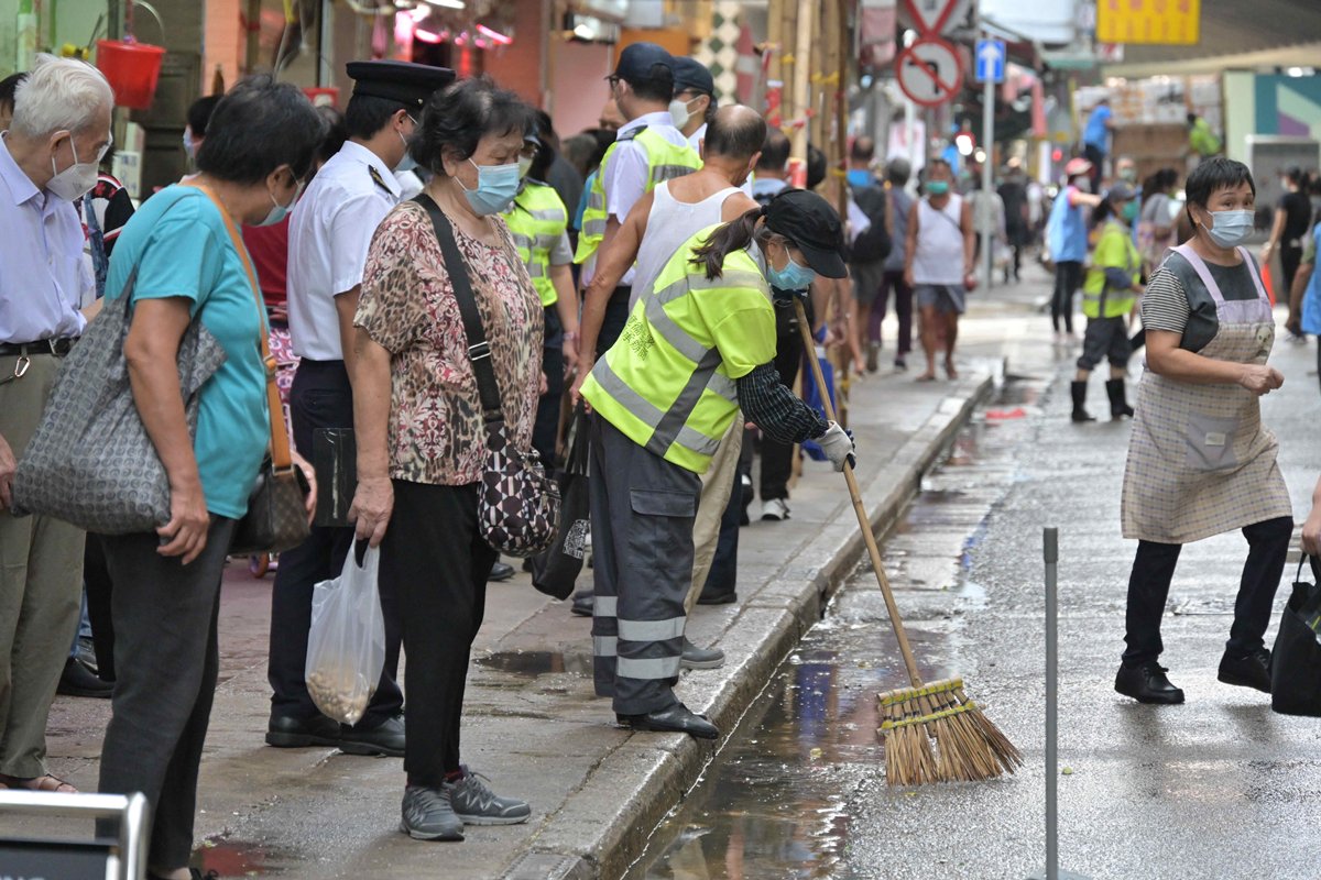 乾淨整潔:  清洗街道後，食環署外判清潔工再清理路邊積水。