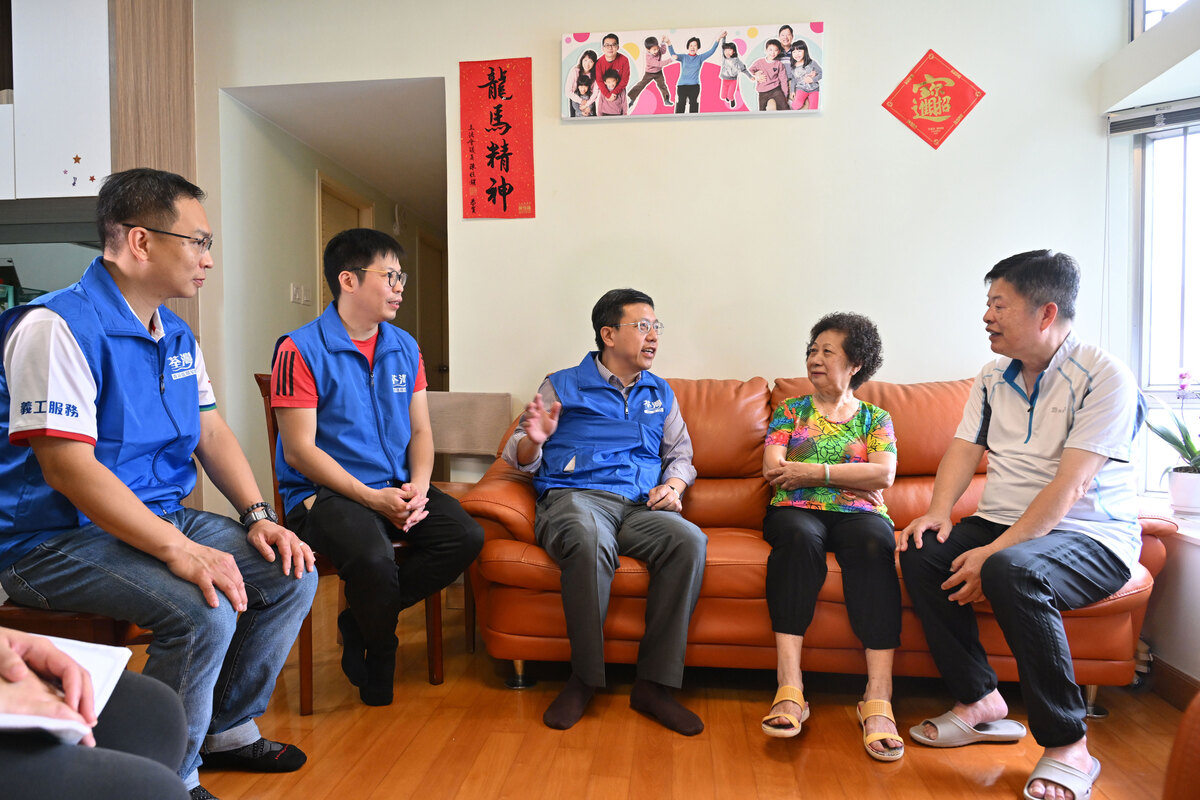 關懷送暖:  區家盛（右三）與荃灣區關愛隊隊員一同探訪區內居民，了解他們的生活情況和需要。