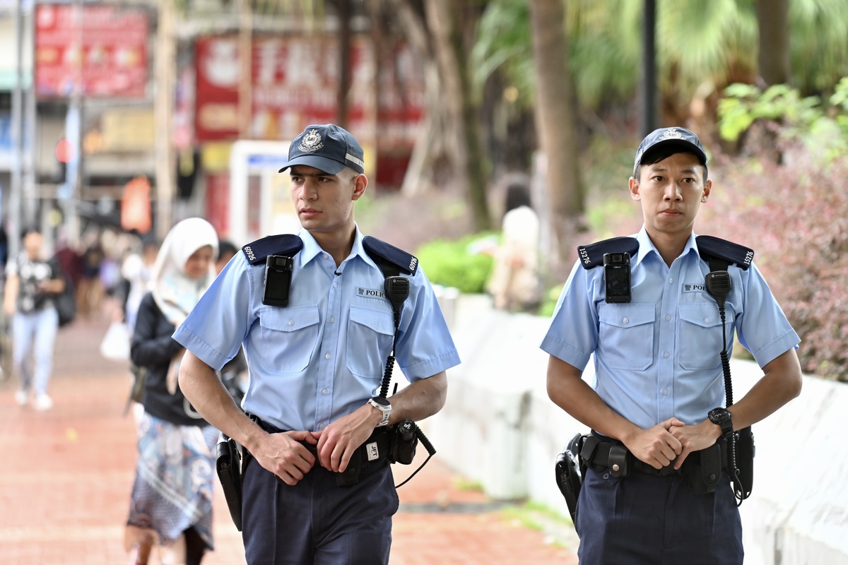 得心應手:  施志深（左）指元朗區較多非華裔人士聚居，他的語言和宗教文化優勢有助交流。