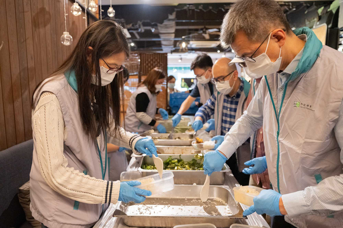 備膳:  地政總署署長黎志華（右）與該署人員參與派福飯義工服務，為有需要長者準備餐膳。