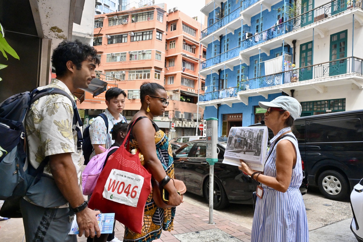 深入社區:  來港人才義工在灣仔居民的帶領下參觀藍屋，了解唐樓的特色和鄰里關係。