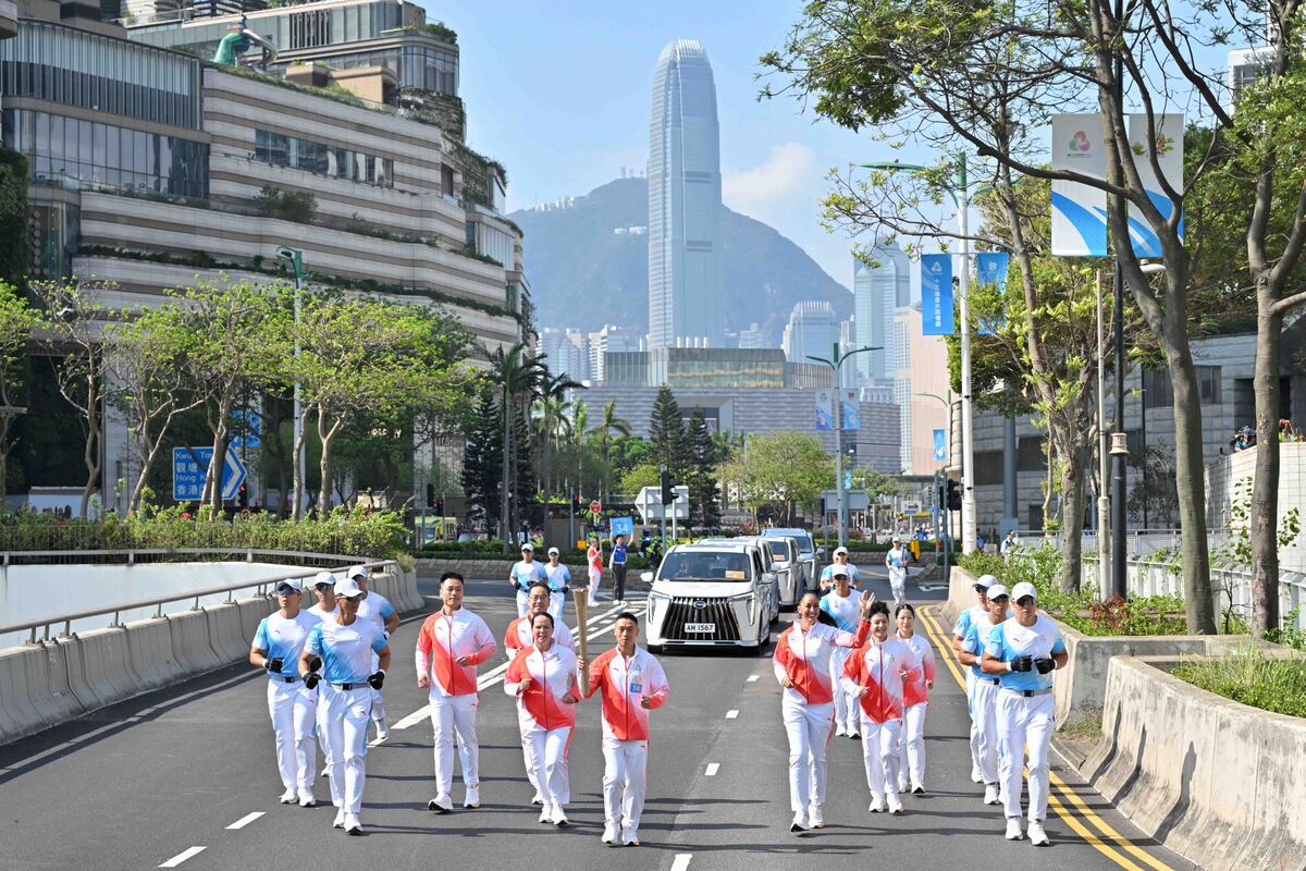 市區穿梭:  火炬傳遞途經尖沙咀。圖為第34棒火炬手何澤堯（中）與助跑火炬手。