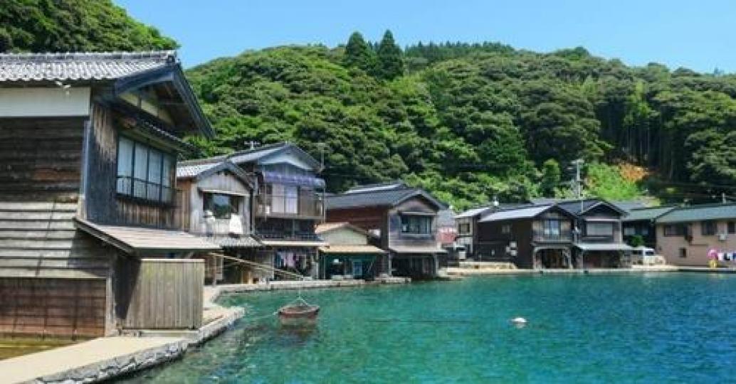 藍綠色的海水襯托整排小木屋...