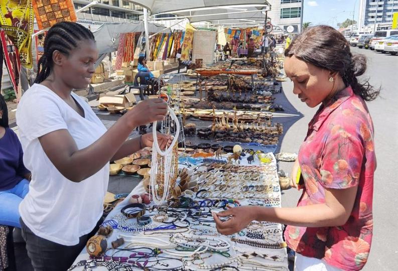 The display of colorful artistic items adorned the floor and stalls at a bustling informal market in... The display of colorful artistic items adorned the floor and stalls at a bustling informal market in...