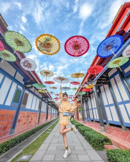 一面美麗的紙傘天空在古厝旁展現...