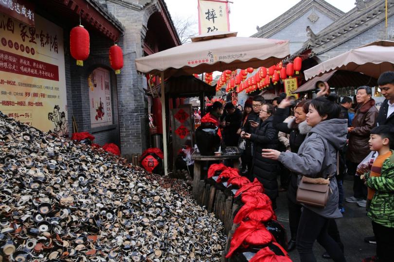 夜晚，西安永興坊掛滿了燈籠，每一個上面都寫有書法字「唐夜市」...