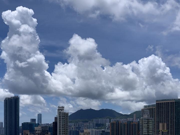 天空的雲變幻無窮，拍攝到好似一列雲山駕在大廈上...