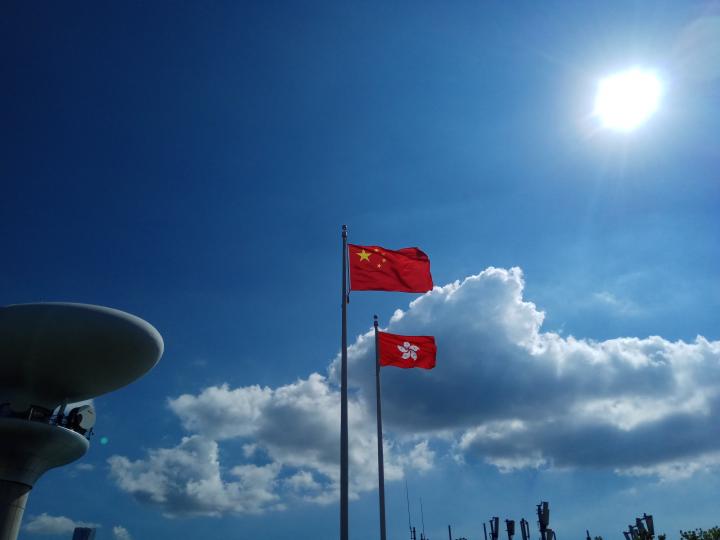 國旗和區旗在藍天白雲下飄揚...