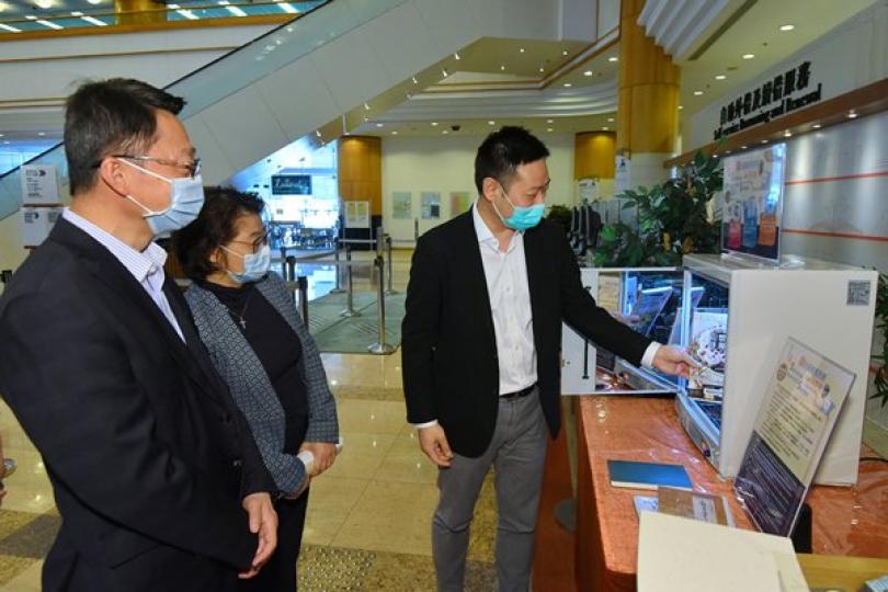 重開在即:  徐英偉（右）到訪香港中央圖書館，試用自助圖書紫外線除菌機。