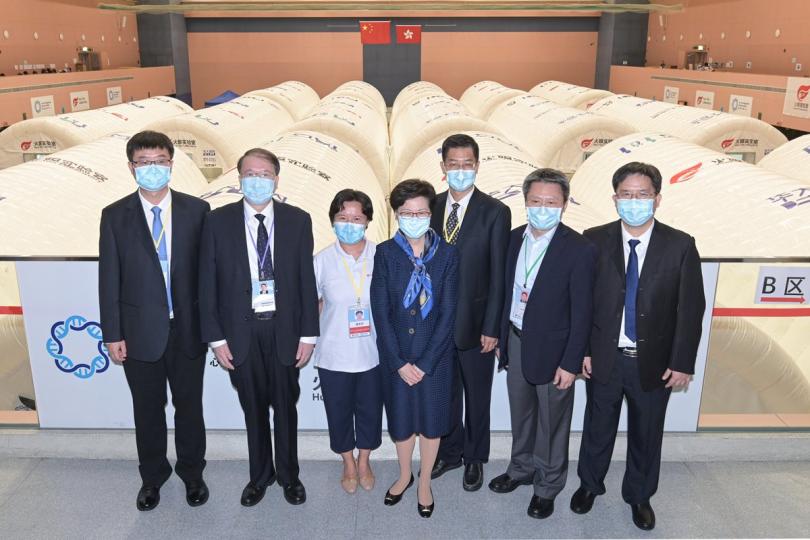 同心抗疫:  林鄭月娥（中）與內地核酸檢測支援隊（支援隊）總領隊、國家衞生健康委員會醫管局副局長李大川（右三）、實驗室總指揮唐美芳（左三）、支援隊（廣東組）隊長余德文（右二）、支援隊（福建組）隊長張永裕（左二）、支援隊（廣西組）隊長龐軍（右一）和衞健委醫療管理服務指導中心處長趙靖合照。