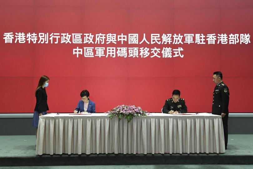 履行責任:  林鄭月娥（左二）和中國人民解放軍駐香港部隊司令員陳道祥少將（右二）簽署《中區軍用碼頭移交備忘錄》。