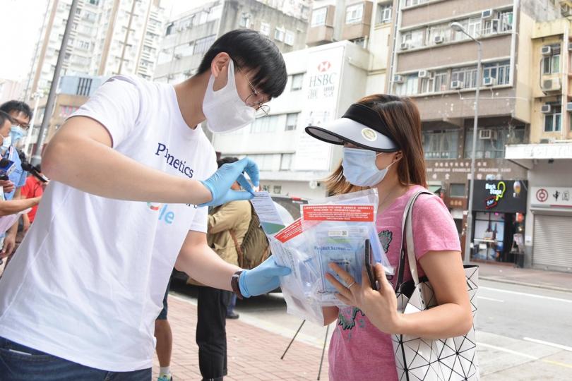 方便巿民:  政府安排的檢測承辦商人員在大埔向居民派發深喉唾液樣本瓶。