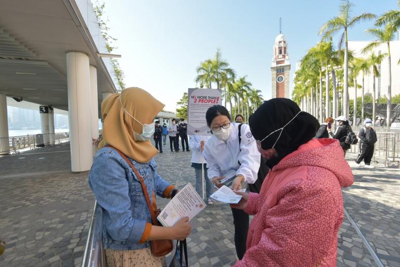 善意提醒:  政府在長假期採取跨部門防疫行動，包括在尖沙咀文化中心附近向外傭派發宣傳單張，提醒他們遵守限聚令及佩戴口罩。