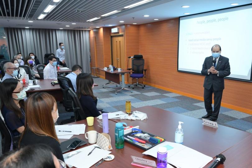 分享心得:  張建宗（右）視察公務員培訓處，與參加公共行政領袖實踐課程的學員交流。