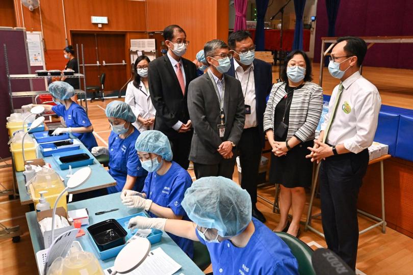 積極參與:  政府外展到校接種新冠疫苗服務展開，聶德權（右）到伊利沙伯中學舊生會中學視察接種情況和安排。