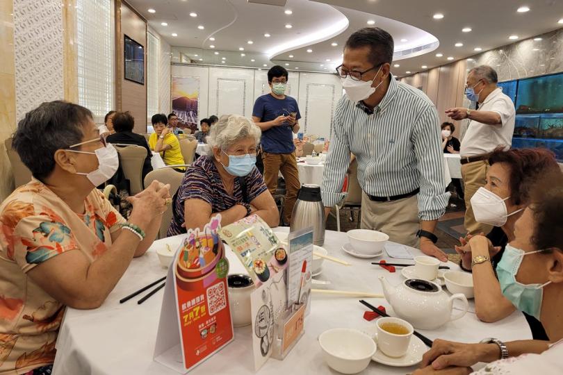 了解民意:  陳茂波（前排中）到香港仔一間酒樓與市民傾談，聆聽他們對消費券的意見。