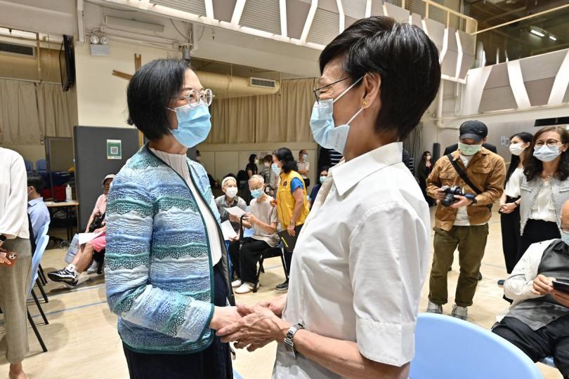 關心社區:  陳肇始（左）出席灣仔區疫苗接種日，與活動參加者傾談。
