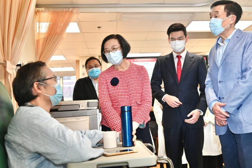關懷病人:  陳肇始（中）到訪中西醫協作住院服務病房時與病人交談。