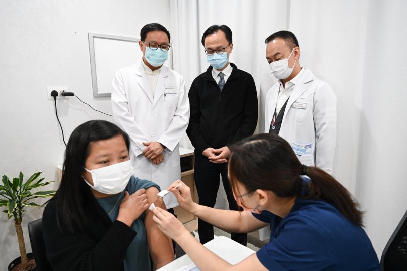 實地視察:  聶德權（後排中）到一間參與先導計劃的診所視察，了解診所提供的新冠疫苗接種服務。