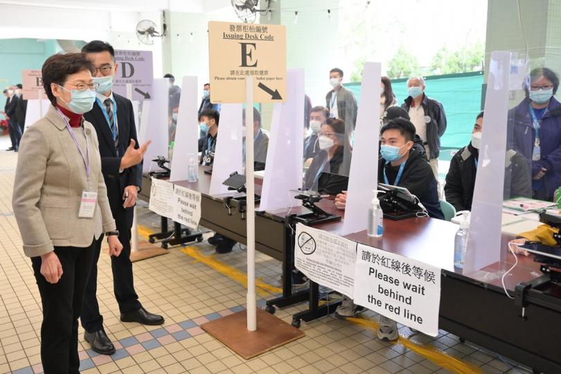 高效運作:  林鄭月娥（左一）巡視設於仁濟醫院羅陳楚思中學的投票站，了解運作。
