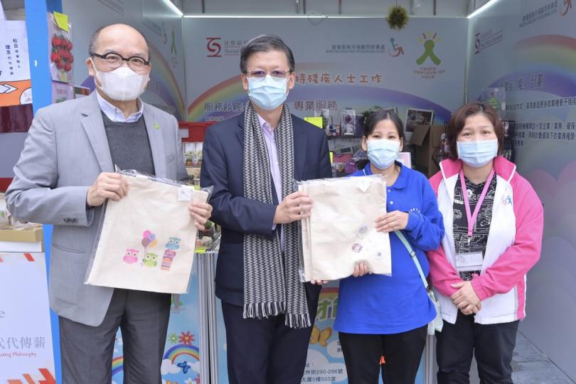 展才能:  梁松泰（左二）在工展會為參展的康復服務單位工作人員打氣。