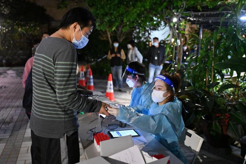 登記檢測:  工作人員在何文田仁禮花園B座受限區域內為受檢人士登記檢測。
