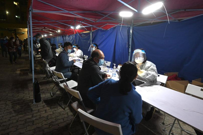 強制檢測:  工作人員在大埔太和邨居和樓受限區域為受檢人士登記檢測。