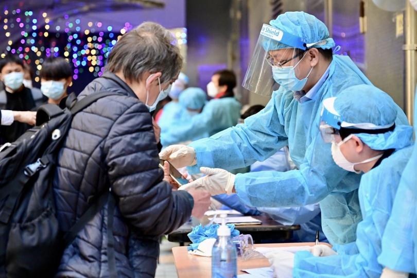 仔細查核:  房屋署人員在葵涌邨逸葵樓受限區域執法，以確認居民有否接受強制檢測。