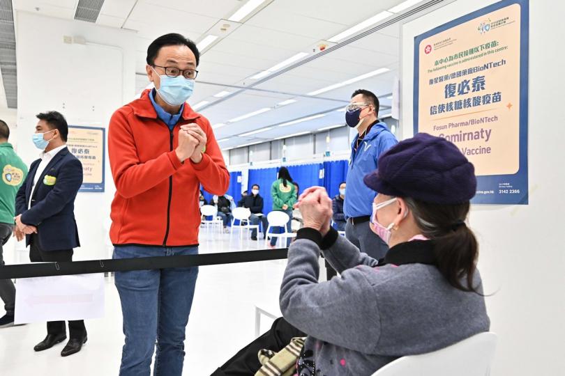 視察運作:  聶德權（左）到教育局九龍塘教育服務中心社區疫苗接種中心視察，其間與剛接種疫苗的市民交談。