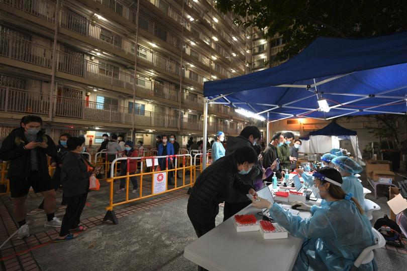 謹遵規定:  香港仔華富（一）邨華裕樓昨晚劃為受限區域，受檢人士在工作人員安排下準備接受病毒檢測。