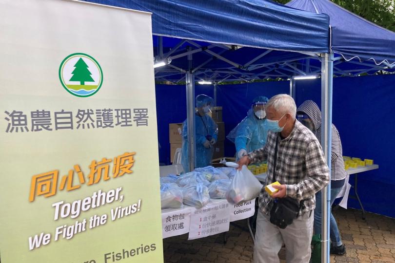 抗疫送暖:  政府人員在祥智樓向受檢居民派發食物包、快速抗原測試套裝和中央政府捐贈的抗疫中成藥。