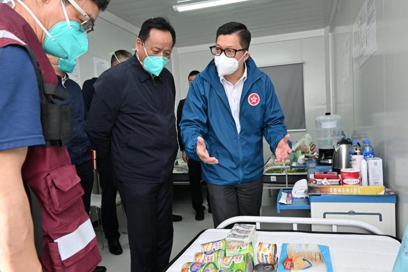 以人為本:  鄧炳強（右一）向仝小林（左二）和專家組成員介紹社區隔離設施內的物資。