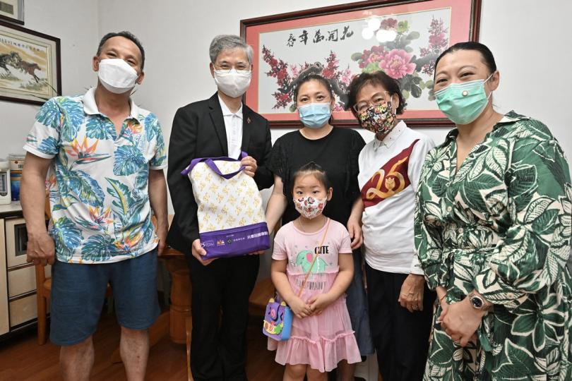 送禮物包:  羅致光（左二）探望東涌基層家庭。