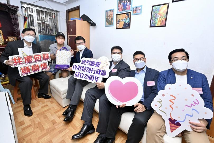 同慶回歸:  邱騰華（左三）探訪中西區一個少數族裔家庭，送上特區成立25周年慶祝活動禮物包。