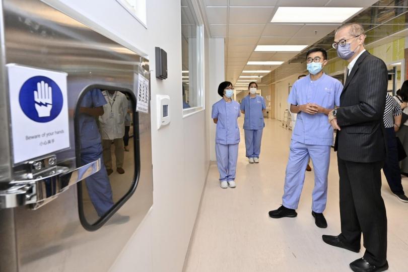 精準防疫:  盧寵茂（右）視察北大嶼山醫院香港感染控制中心，了解醫護人員對新冠肺炎病人的治療護理工作。   