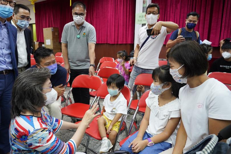 保護幼童:  楊何蓓茵（前排左一）到深水埗出席疫苗接種活動，其間與完成接種疫苗的兒童傾談。