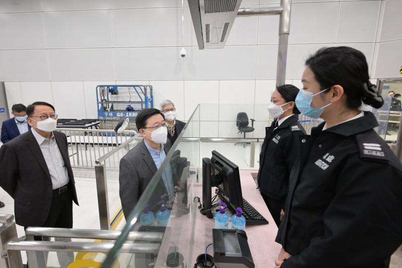 視察通關:  李家超（左二）到落馬洲支線管制站視察首日通關情況，並與入境事務處人員交談。旁為陳國基（左）。