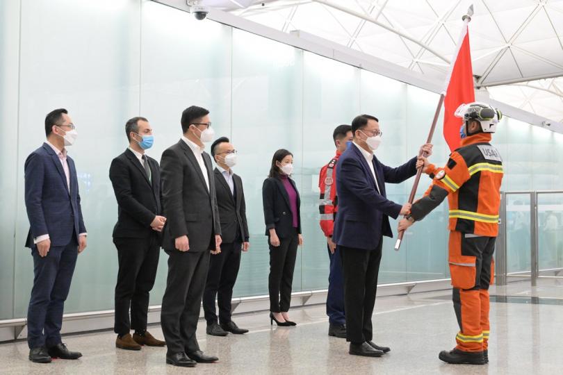 致敬:  陳國基（右二）在機場授旗予特區搜救隊伍代表。