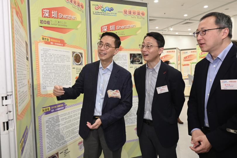 文化交流:  楊潤雄（左）欣賞「4．23世界閱讀日創作比賽」粵港澳大灣區的得奬作品。