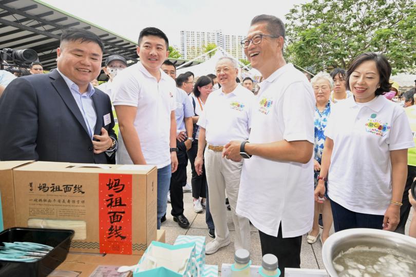 佳餚當前:  陳茂波（右二）和麥美娟（右一）參觀美食市集，與參展商交談。