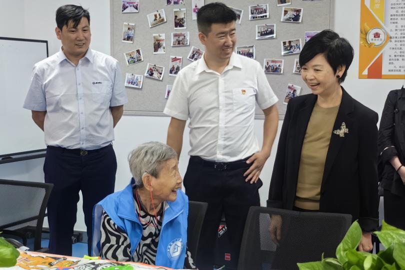 走進民居:  何永賢（右一）到訪北京一個社會保障性住房項目期間與居民傾談，了解他們的日常生活。
