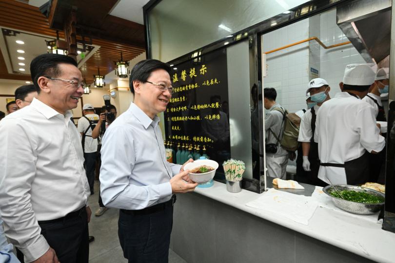 地道美食:  李家超（左二）在貴州省委常委、宣傳部部長盧雍政（左一）陪同下，到當地食店享用早餐。