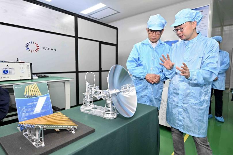 前沿技術:  陳茂波（左）到訪一家衞星製造和提供衞星互聯網解決方案的企業，參觀研發中心和新一代衞星產品。