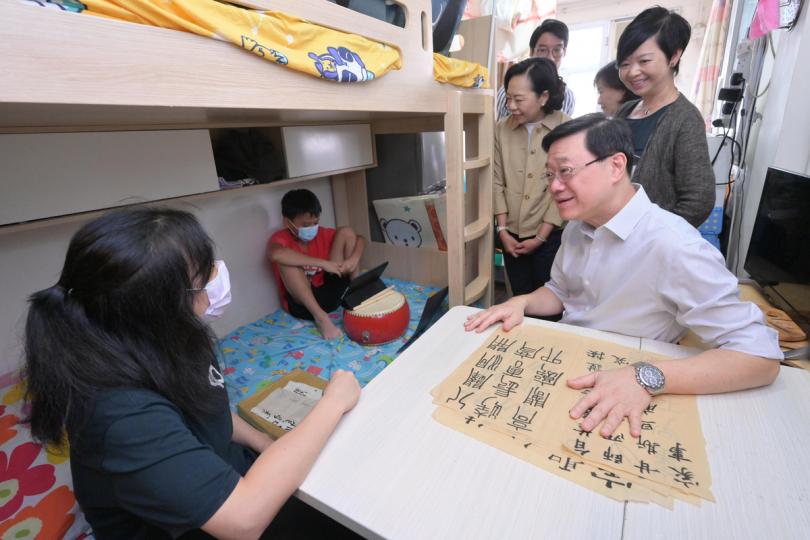 實地了解:  李家超（前排右）探訪居於劏房的基層家庭。